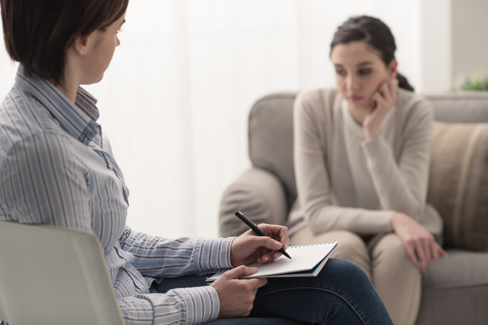 Young female patient talking with her therapist in the office