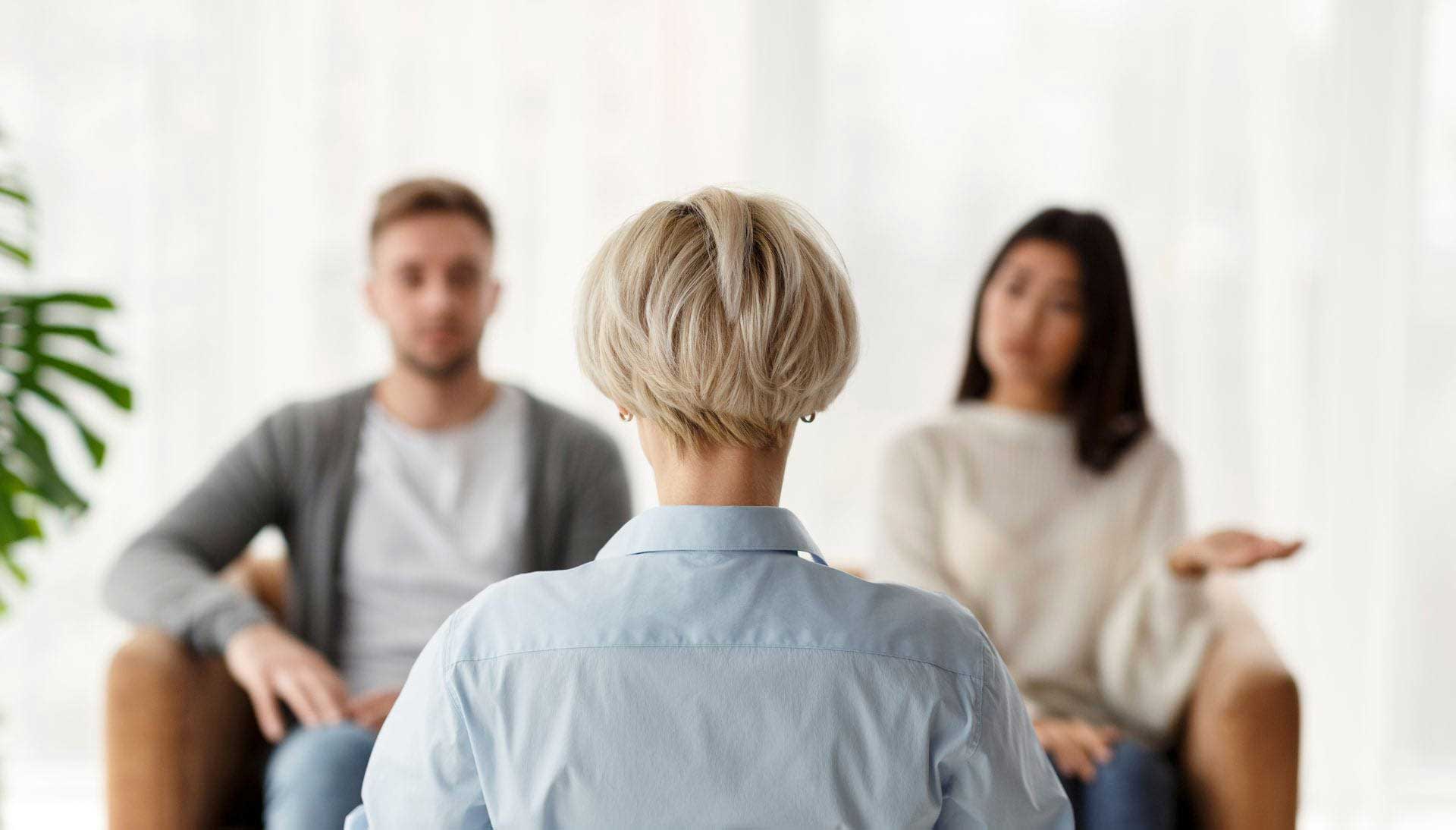 Couples therapy in Hamilton with a therapist with short hair talking to a couple in her white window office