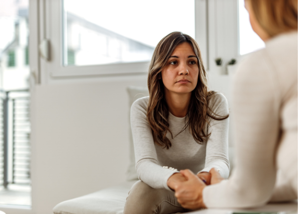 A person sitting on a couch talking to another person